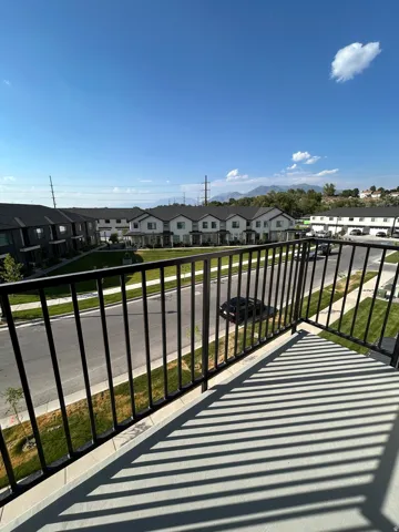 Balcony featuring black metal railings and concrete flooring