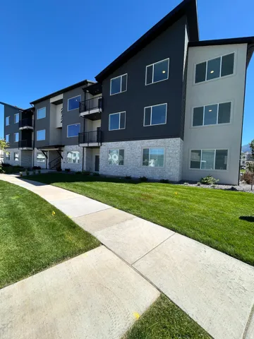 Modern exterior featuring multi-toned siding, stone veneer accents, and private balconies