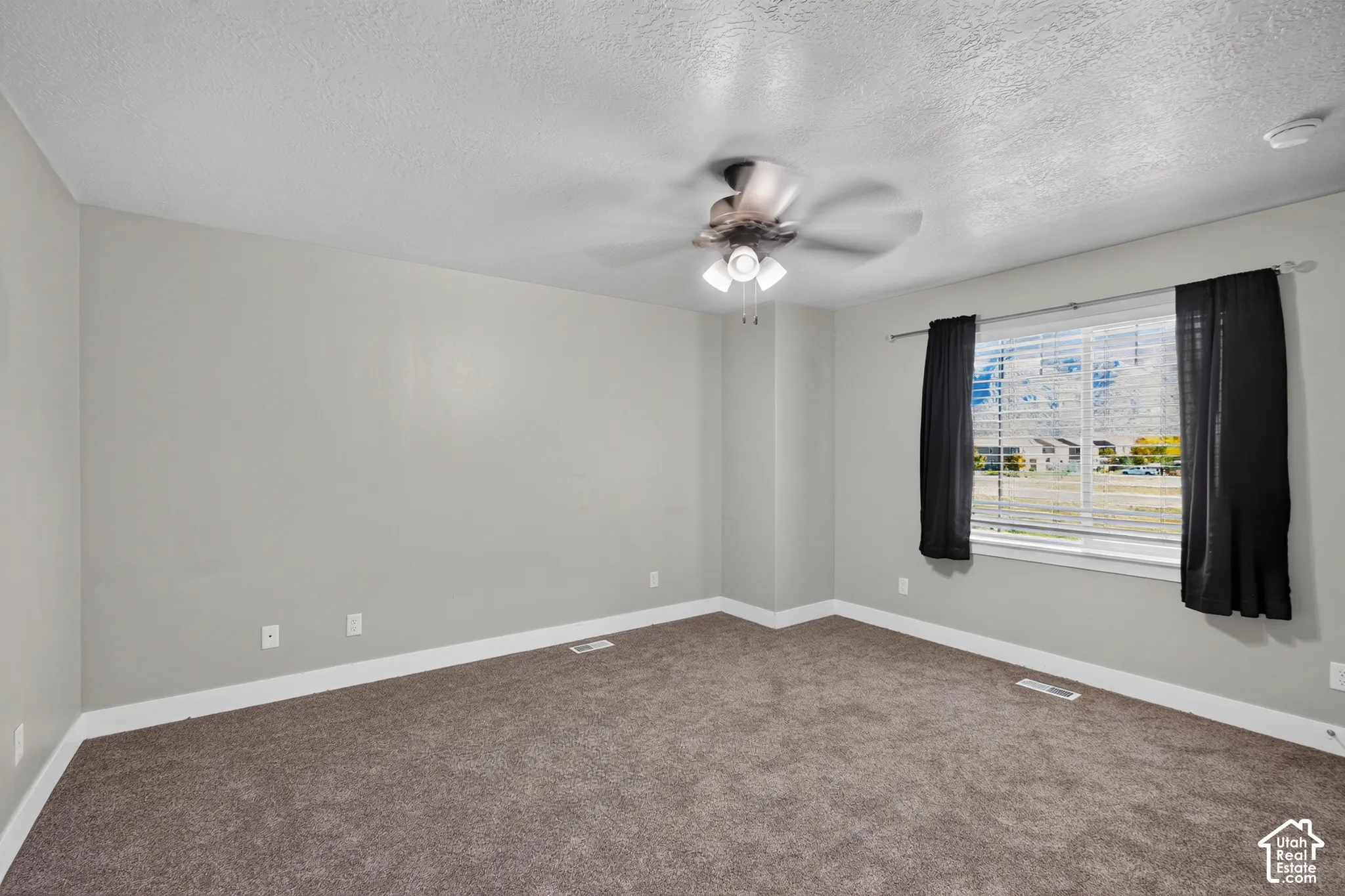 Neutral wall tones paired with carpeted flooring, a multi-blade ceiling fan with integrated lighting, and a window with horizontal blinds
