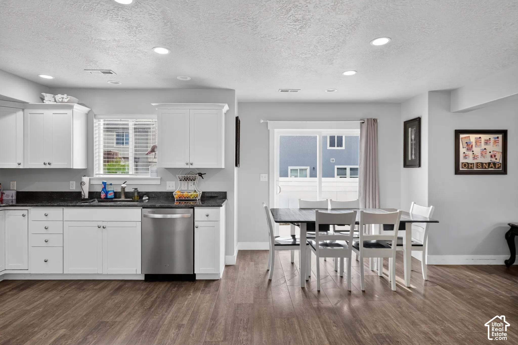 Kitchen featuring white cabinetry, dark countertops, and stainless steel appliances