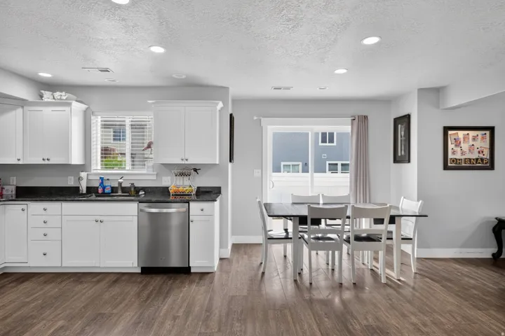 Kitchen featuring white cabinetry, dark countertops, and stainless steel appliances