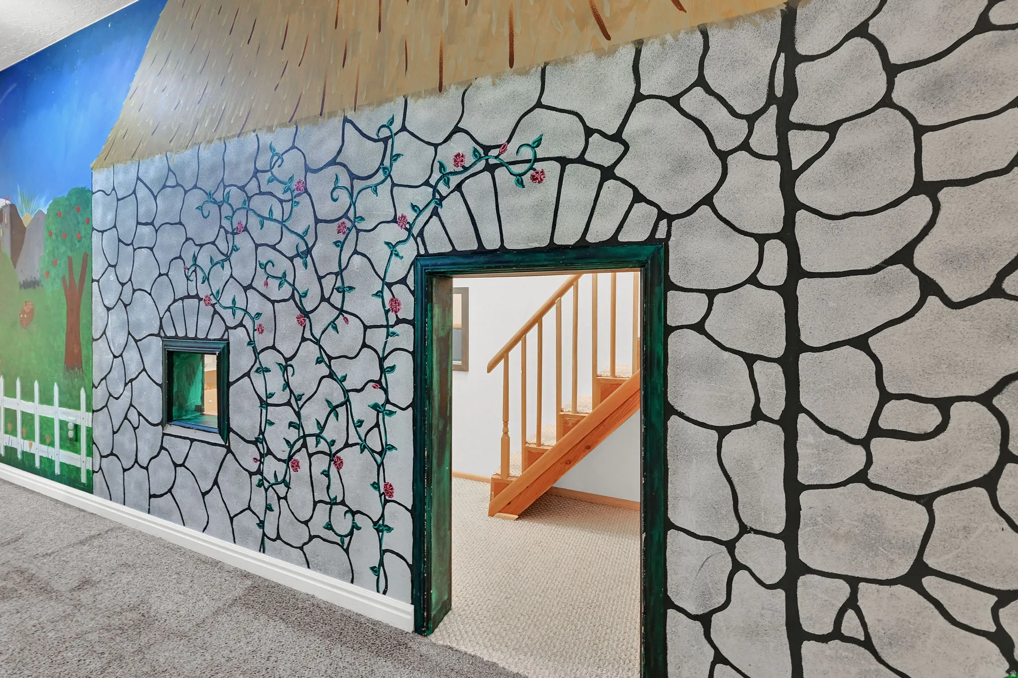 Decorative wall mural with stone-pattern design and painted vine accents for the exterior of the kids playroom.