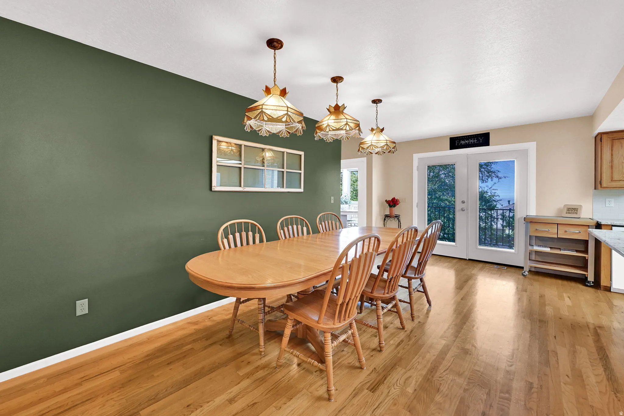 Hardwood flooring, painted accent wall, and access through the double glass-paneled doors to the deck.