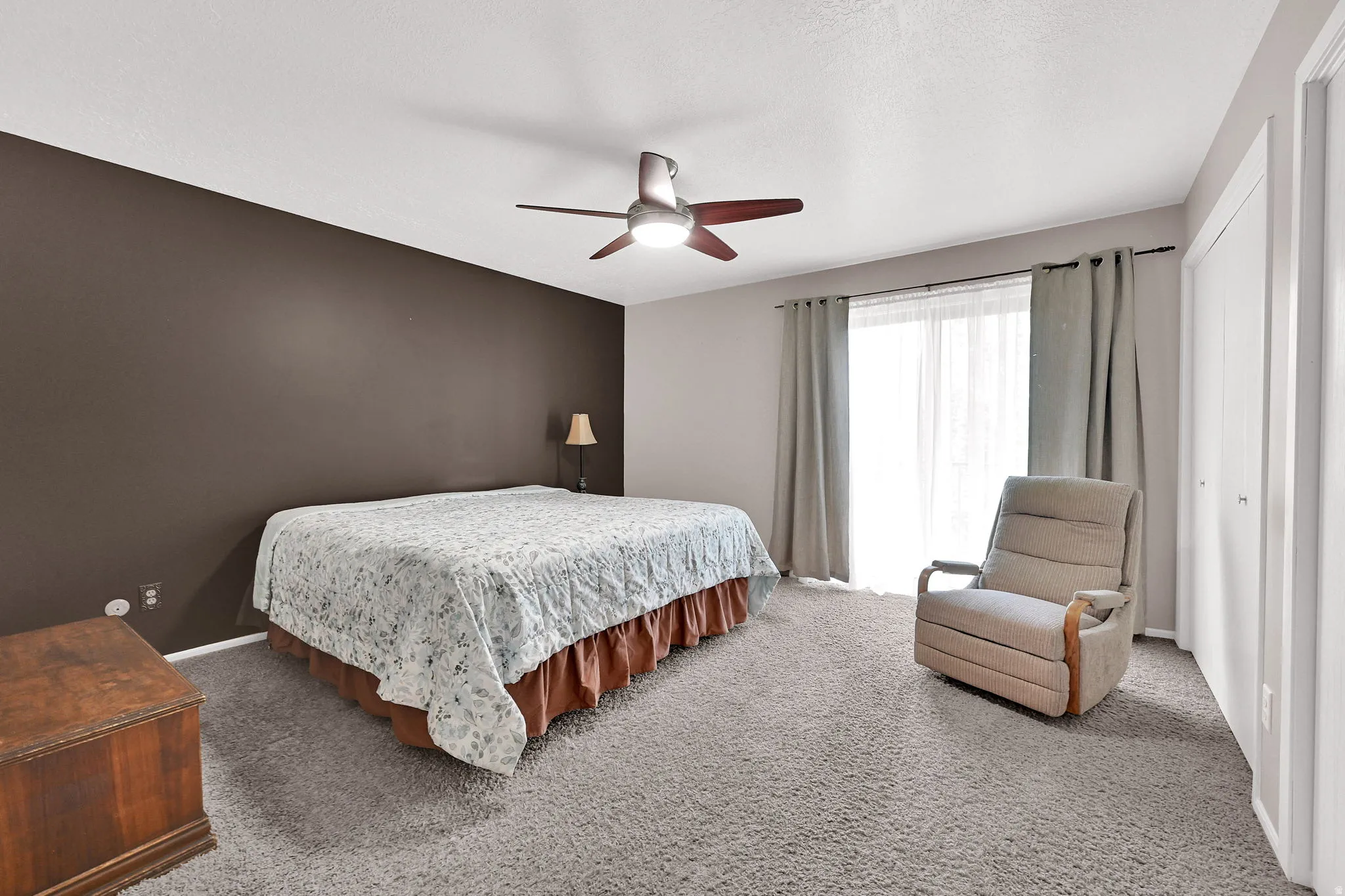 Wall-to-wall carpeting, ceiling fan with integrated lighting, sliding glass door to a private deck, and double-door closet.