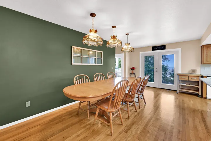 Hardwood flooring, painted accent wall, and access through the double glass-paneled doors to the deck.