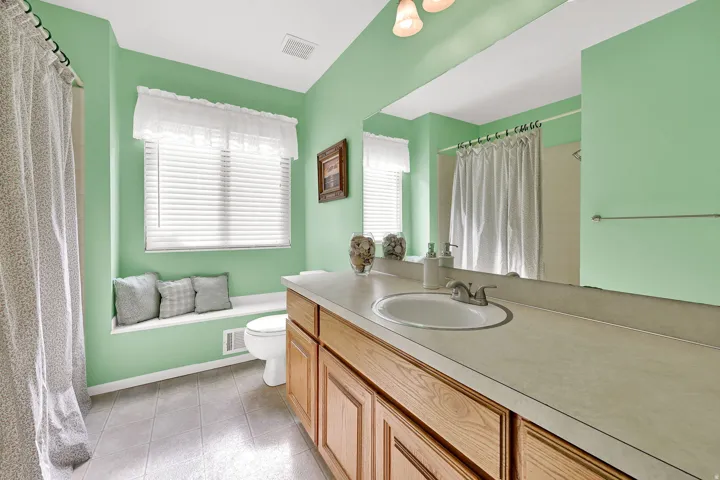 Bathroom with a window, single vanity and a tub/shower combo.