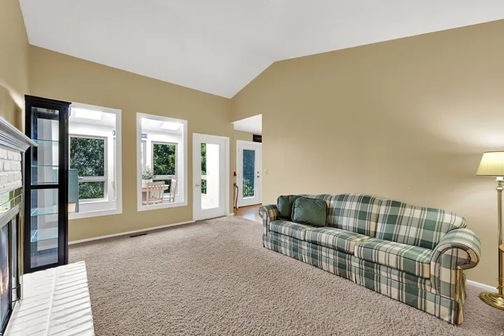 Vaulted ceiling with a white brick fireplace and views to the backyard.