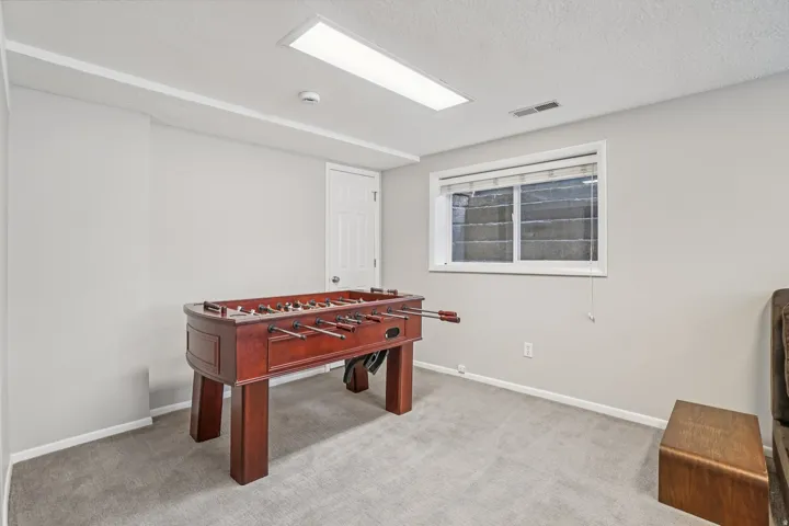 Carpeted flooring, recessed lighting, and a single window with blinds