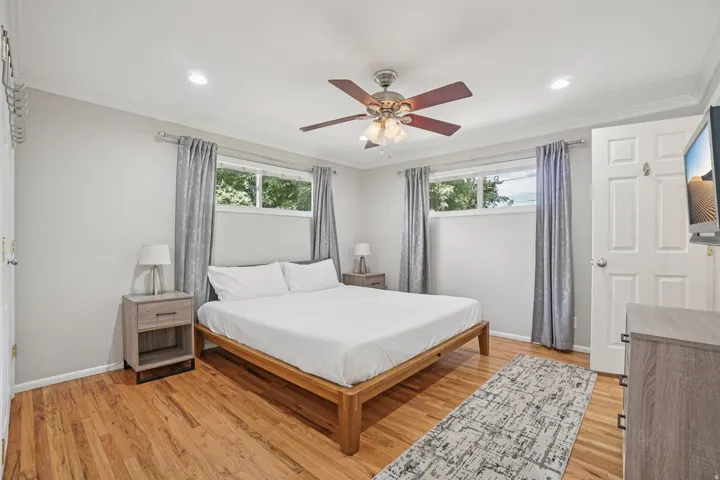 Wood-finish flooring, recessed lighting, ceiling fan, and two windows with natural light