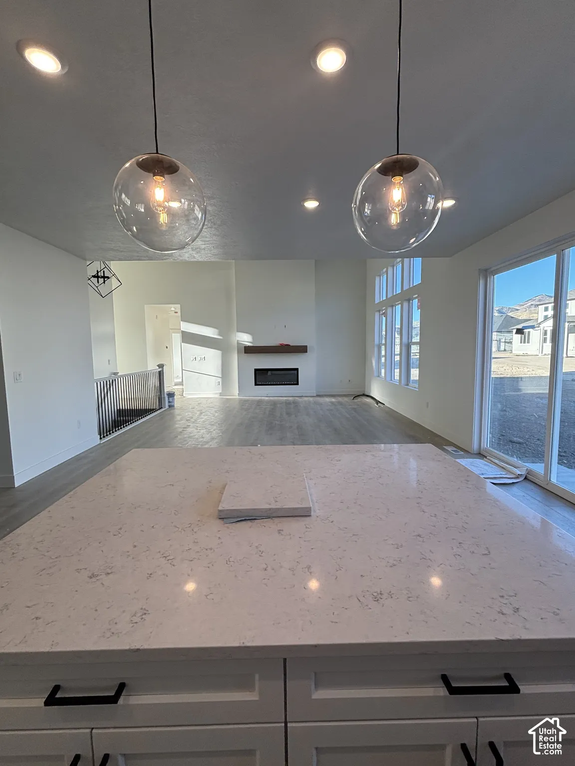 Kitchen island featuring a spacious countertop and white cabinetry with black hardware