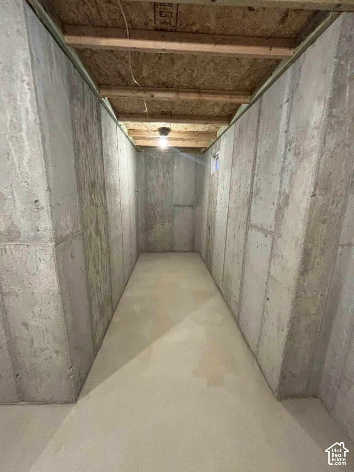 Concrete foundation walls with exposed wood joists and subfloor