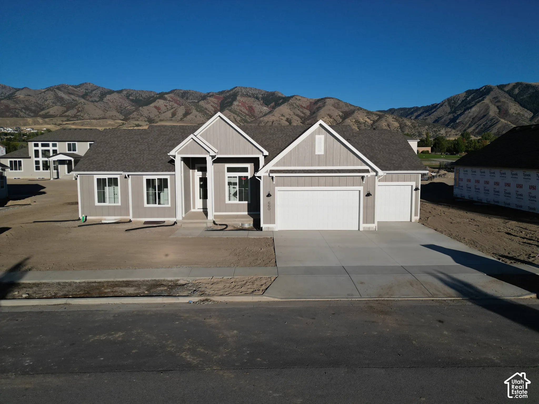 Contemporary home with a light gray exterior, a two-car garage, and a single-car garage