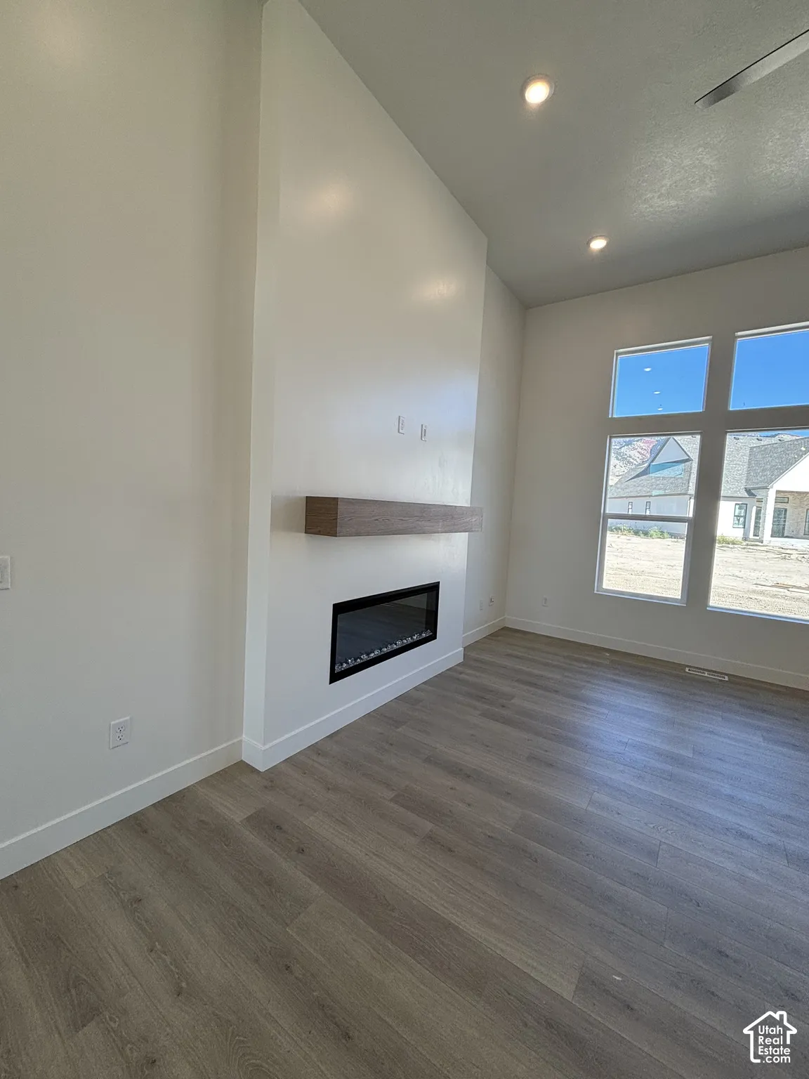 Contemporary fireplace with a wood-finish mantel and recessed lighting