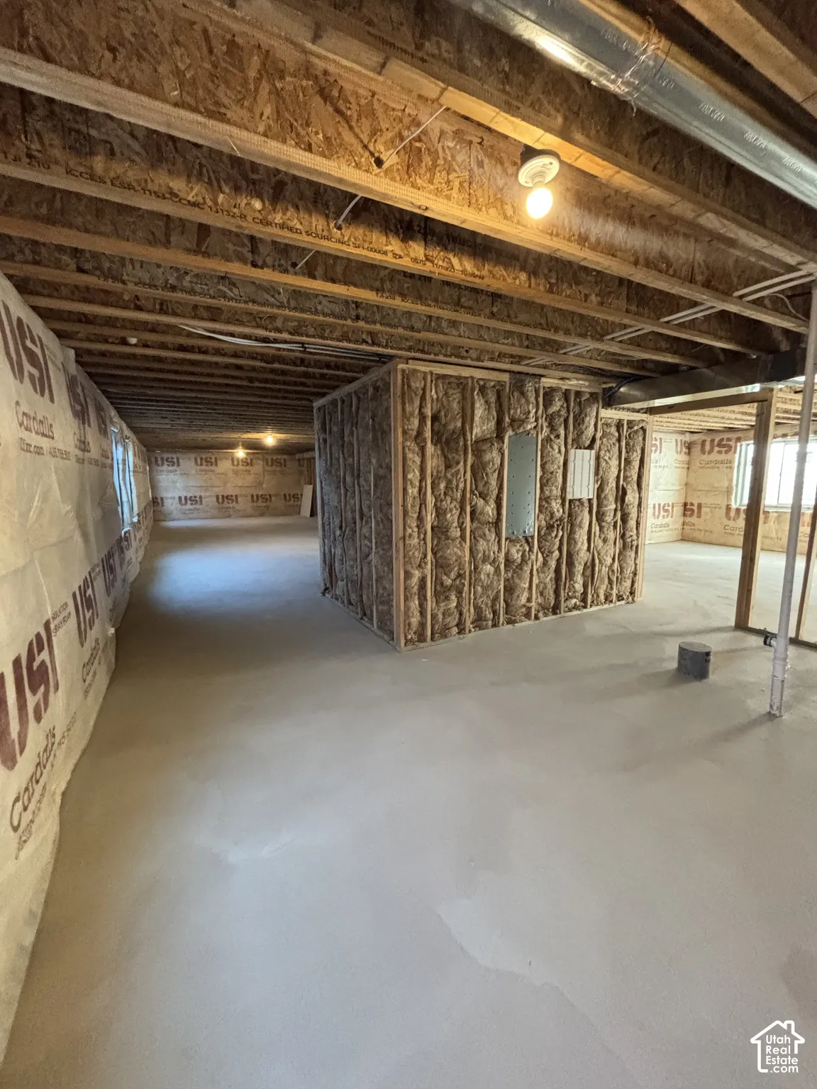 Exposed wood beam ceiling, concrete flooring, framed interior wall, and wall insulation