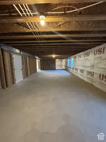 Unfinished lower level featuring exposed ceiling joists, framed interior walls, and concrete flooring