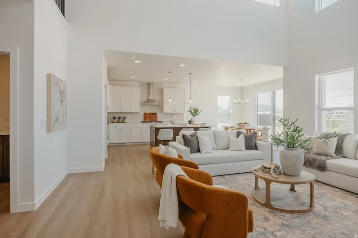 Expansive living area with high ceilings, recessed lighting, and wood-finish flooring