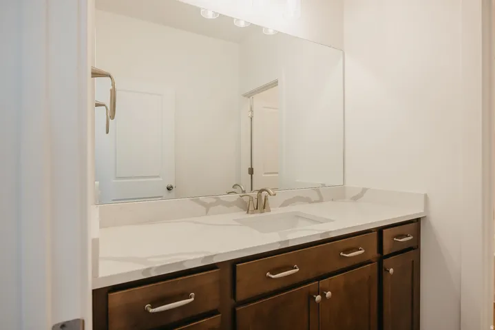 Vanity with a white countertop and integrated sink, complemented by a brushed nickel faucet