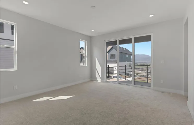 Owner's Suite flooded with natural light through expansive glass sliding doors and windows