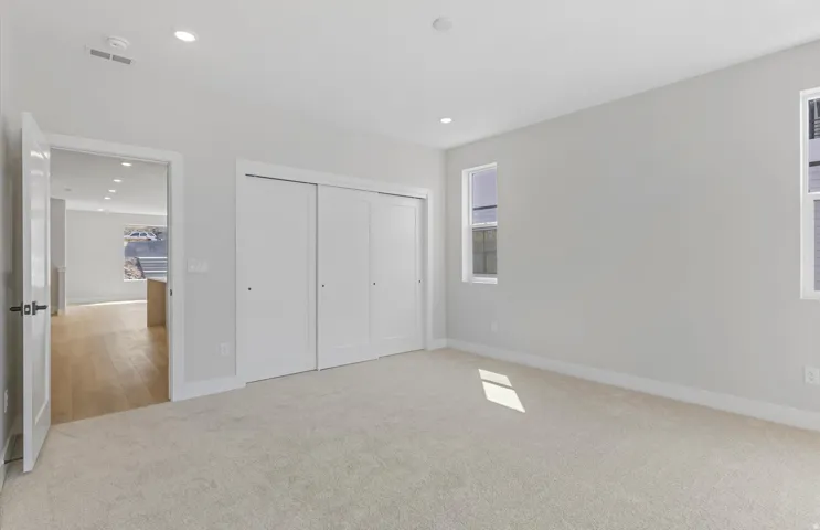 Owner's Suite flooded with natural light through expansive glass sliding doors and windows