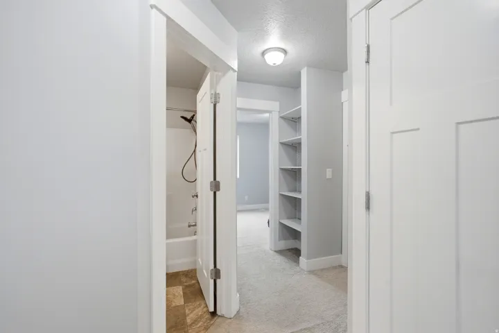 Hallway with access to bedroom 2, full bath, laundry and garage