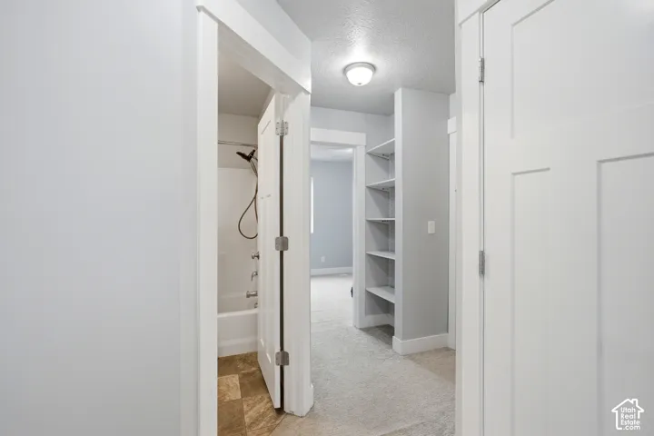 Hallway with access to bedroom 2, full bath, laundry and garage