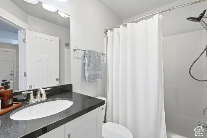 Upstairs hall full bath with white vanity with granite countertop, undermount sink, and brushed nickel faucet