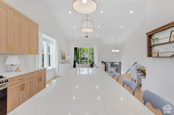 Spacious kitchen island with a light-toned countertop, wood-finish cabinetry, and white tile backsplash