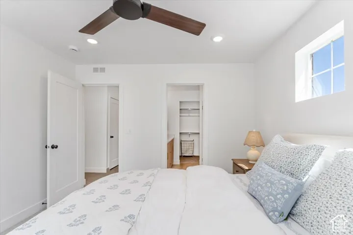 Recessed lighting, ceiling fan with wood-finish blades, white window, and wood-finish flooring