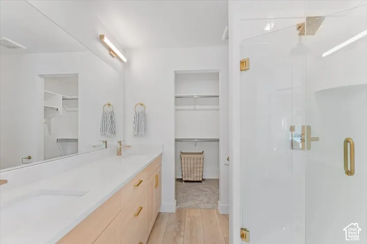 Dual vanity with light wood-finish cabinetry and gold-toned hardware