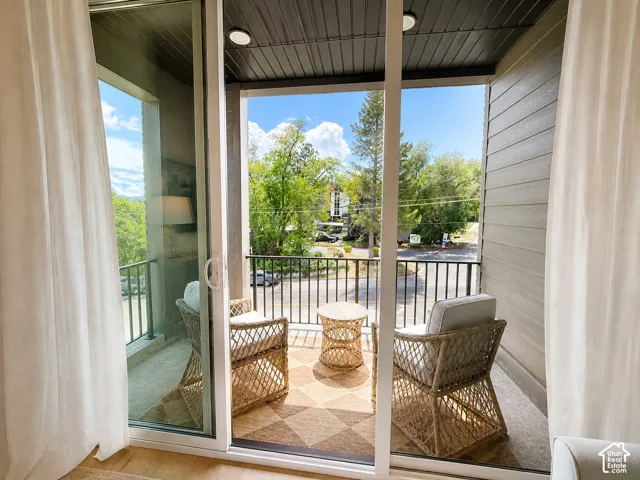 Private balcony with black metal railings, textured exterior siding, and an overhead light fixture