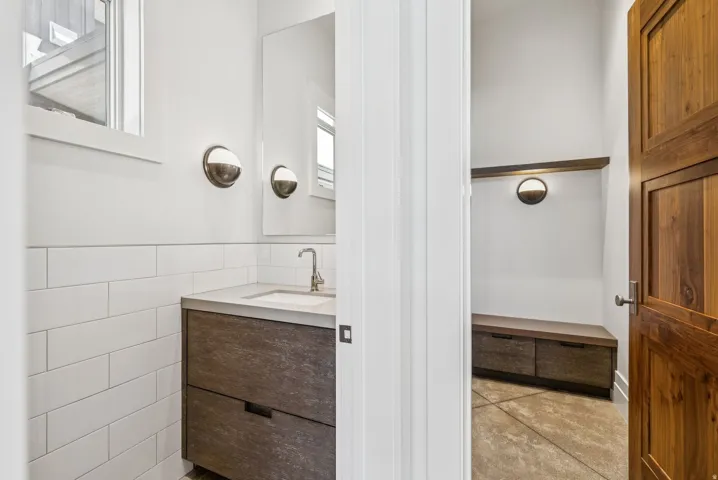 Modern powder room featuring a gray vanity with an integrated sink and chrome faucet