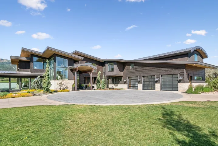 Contemporary architecture featuring dark wood siding and stone accents