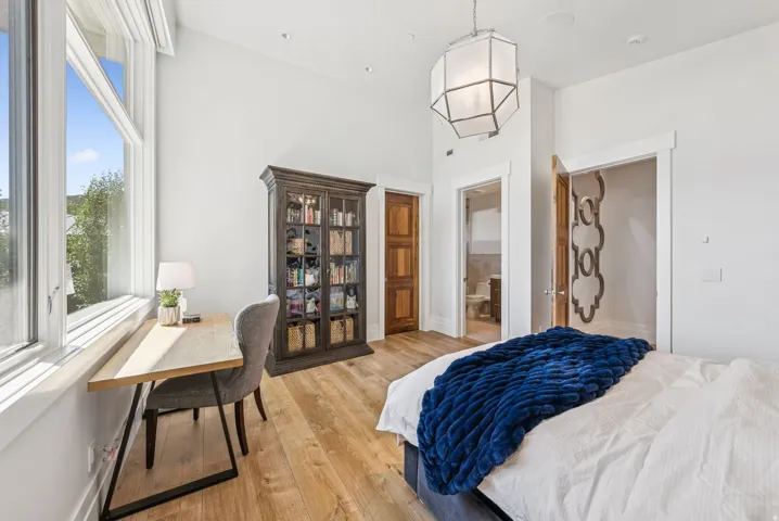 Room featuring wood-finish flooring and a high vaulted ceiling