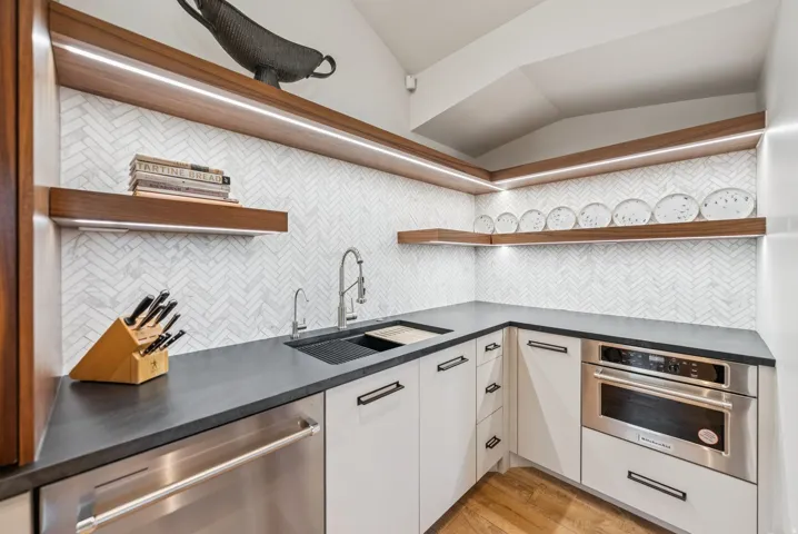Kitchenette featuring a stainless steel dishwasher, built-in microwave, and corner sink