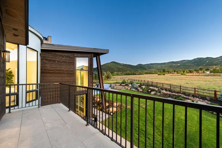 Outdoor balcony featuring large format tile flooring and a black metal railing