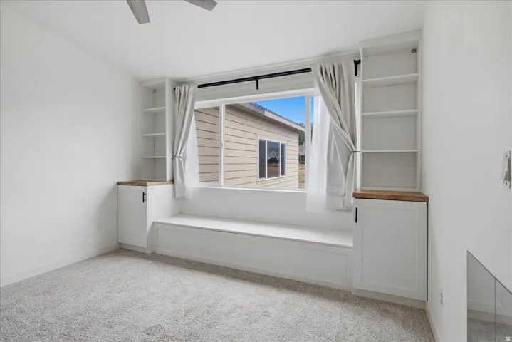 Built-in window bench with integrated storage, flanked by custom cabinetry with wood-finish countertops and open shelving