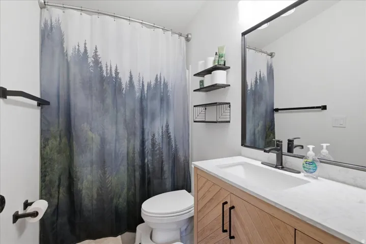 Chevron-pattern wood-finish vanity with a single basin sink and matte black faucet