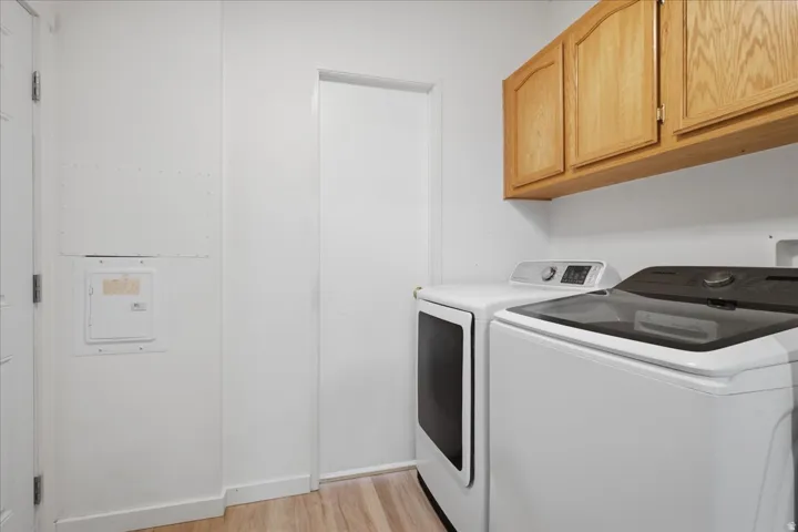 Wall-mounted wood cabinetry, wood-finish flooring, and white walls