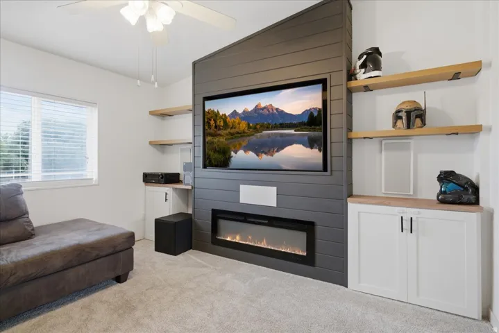 Integrated media wall with horizontal paneling, built-in electric fireplace, and floating wood shelves