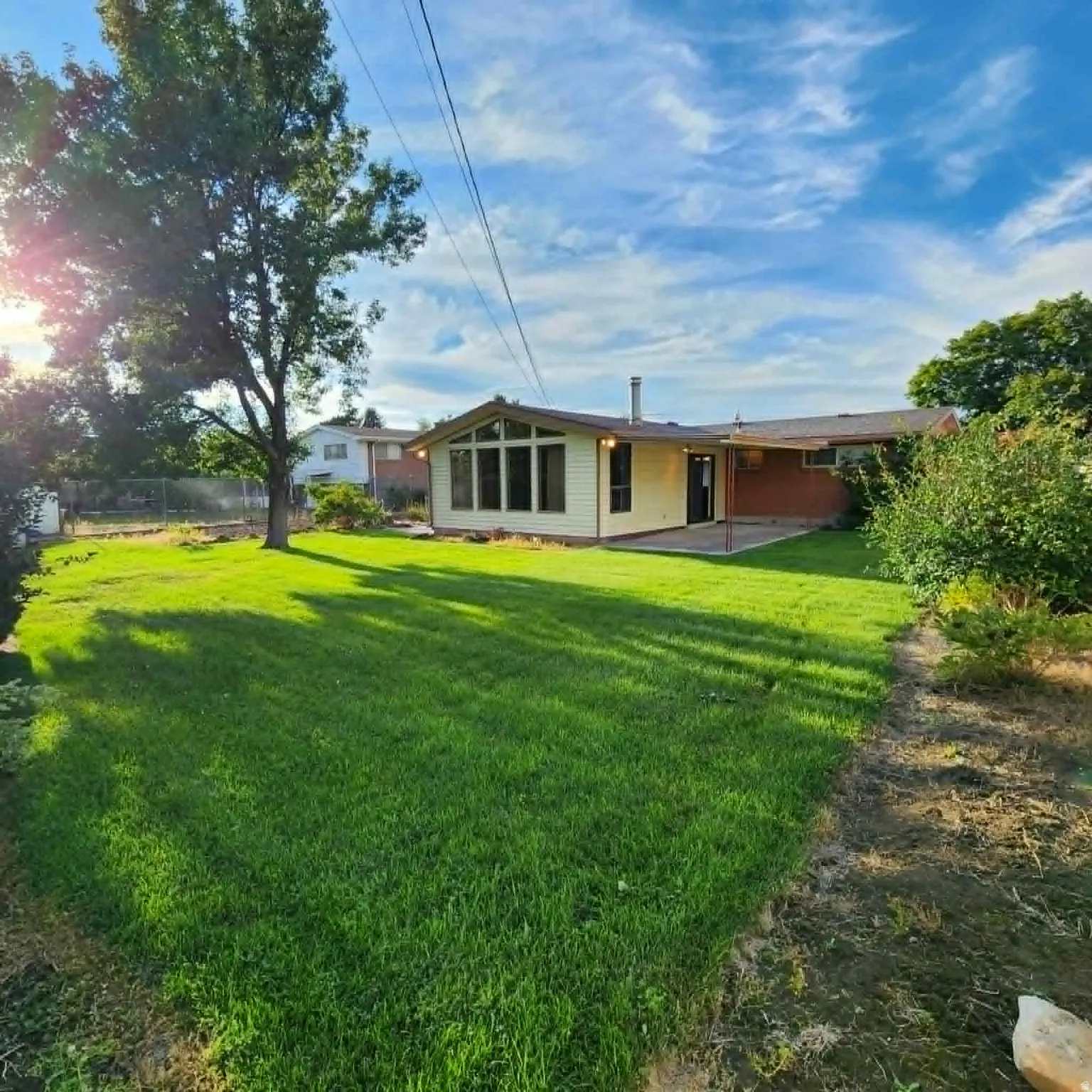 Expansive grassy yard with mature trees