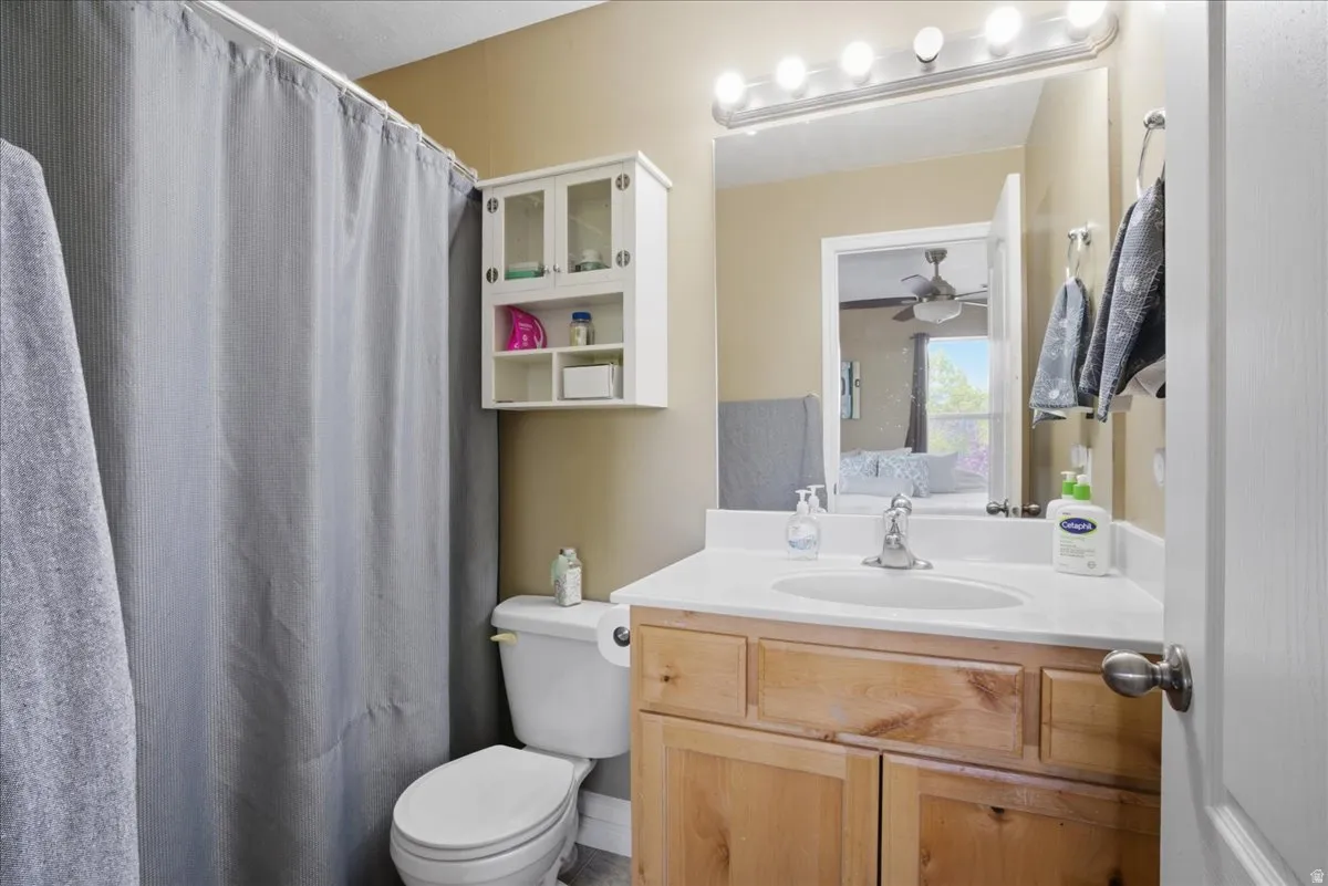Single vanity with wood cabinetry, white countertop, and integrated sink