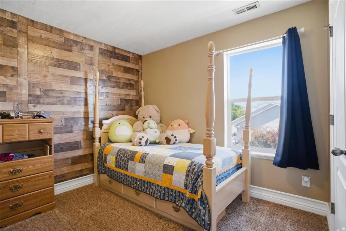 Wood-paneled accent wall, neutral wall color, and carpeted flooring