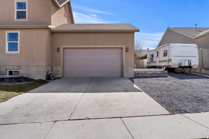 Attached two-car garage with overhead door and dual exterior light fixtures