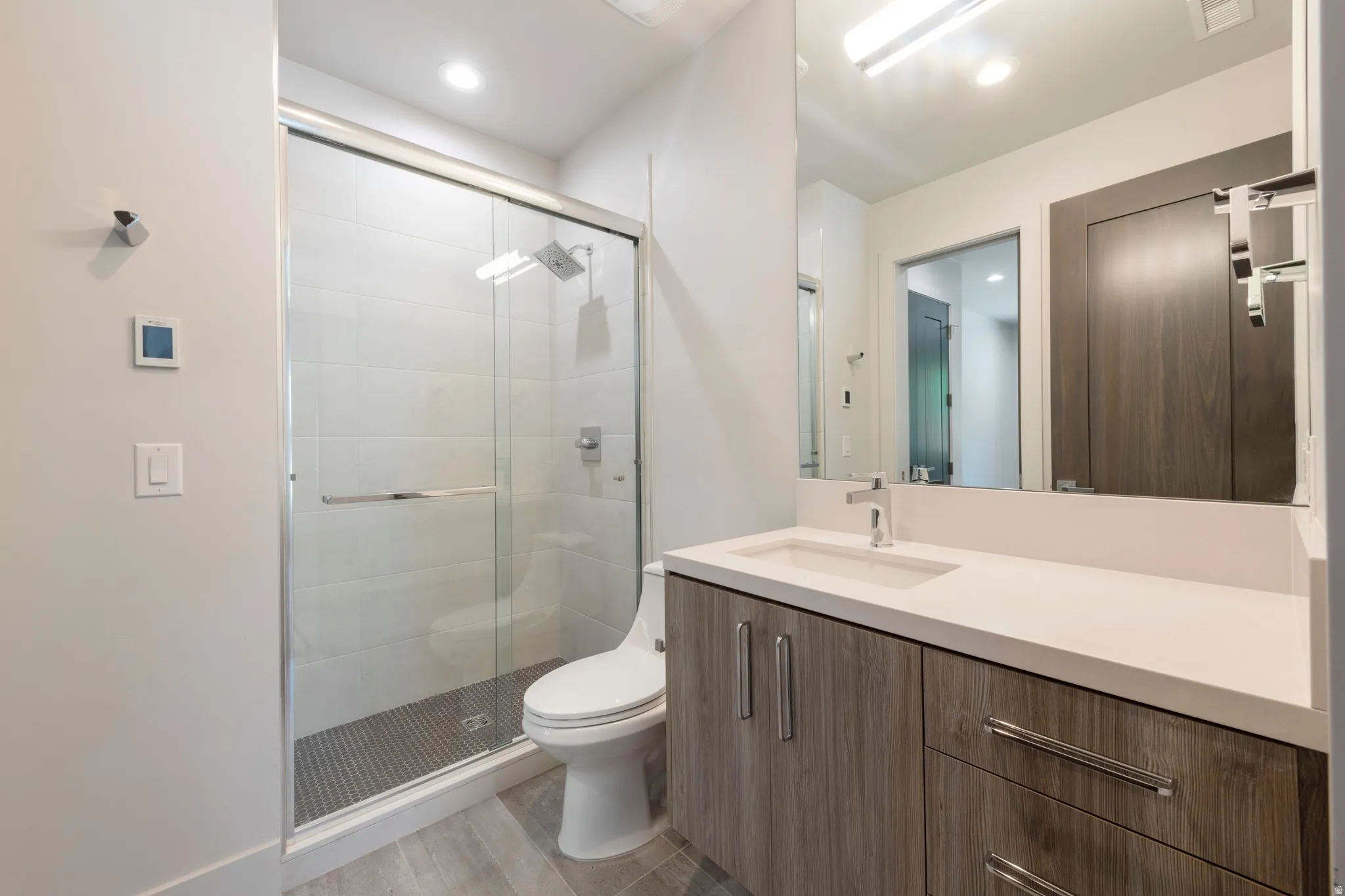 Walk-in shower with clear glass enclosure and rainfall showerhead