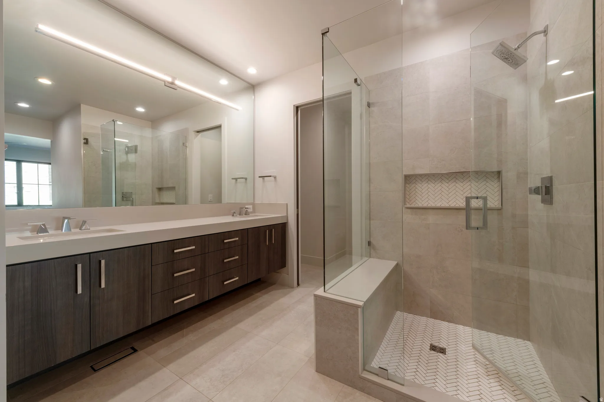 Dual vanity with undermount sinks, wood-finish cabinetry, and a large mirror