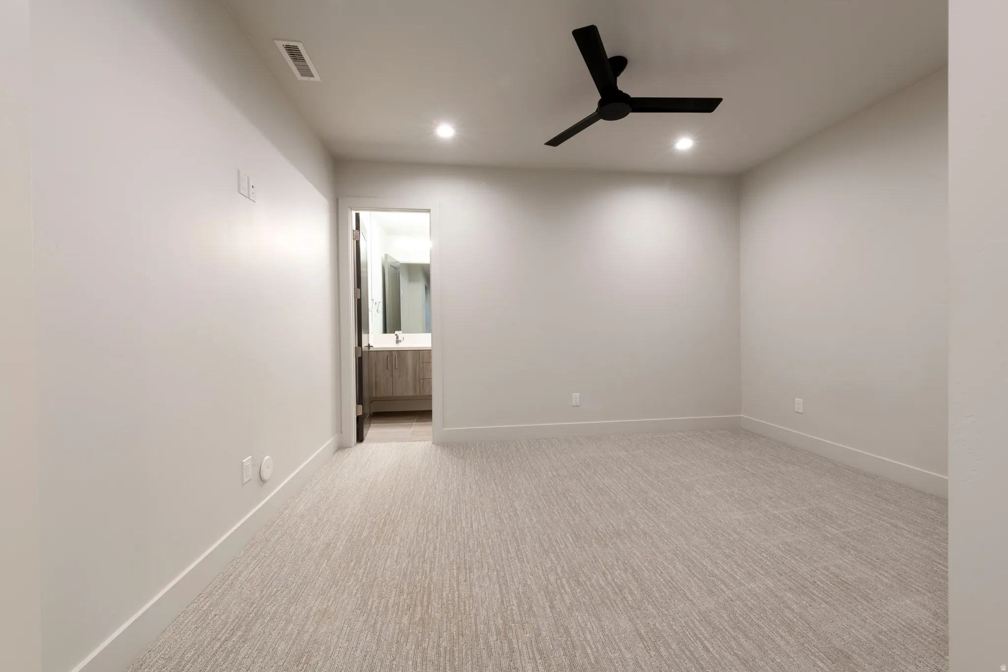Recessed lighting, ceiling fan with matte black finish, light gray walls, and textured carpet flooring