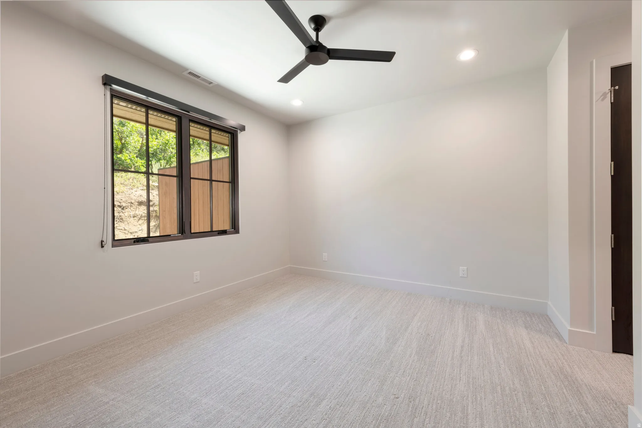 Neutral tone walls, recessed lighting, ceiling fan, and light-toned carpet flooring