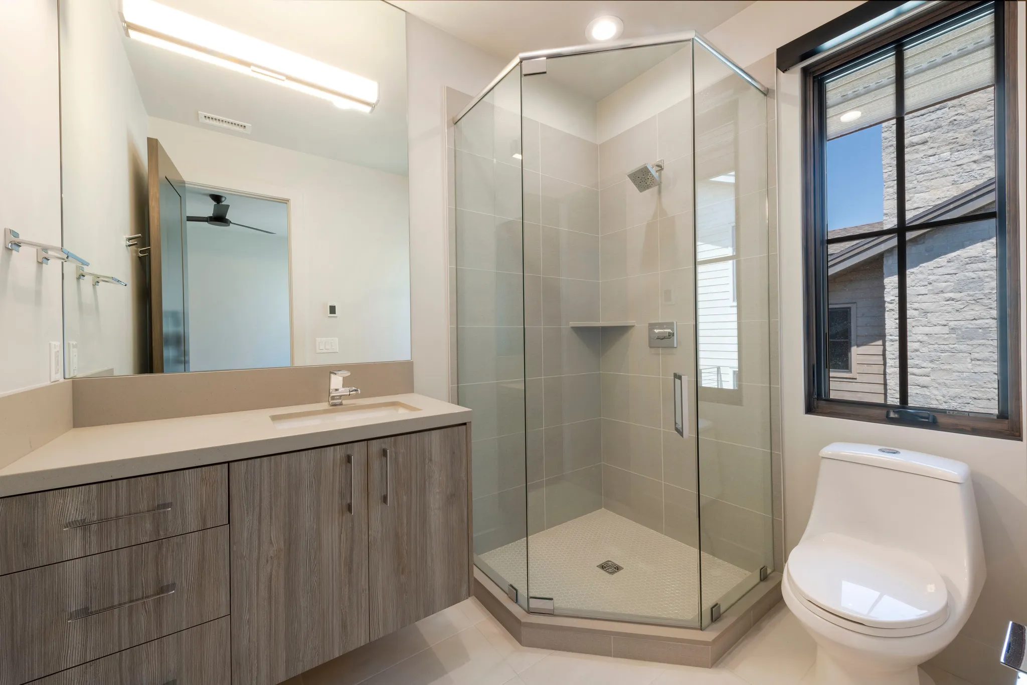 Vanity with a single basin sink and light-toned countertop