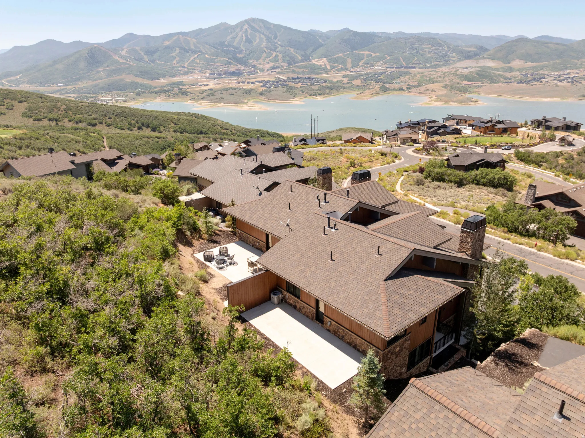Expansive property with a multi-level roofline, stone and wood-paneled exterior, and multiple outdoor patios