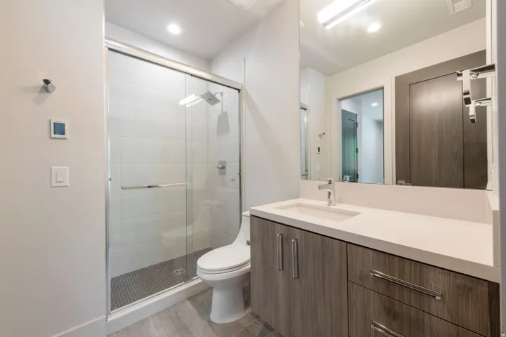 Walk-in shower with clear glass enclosure and rainfall showerhead